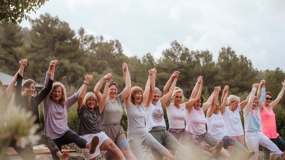 Eine Gruppe Frauen hält sich lachend an den Händen