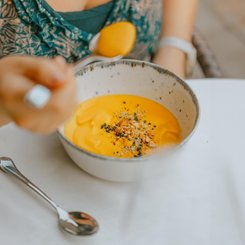 Eine Frau beim Essen einer Kürbissuppe