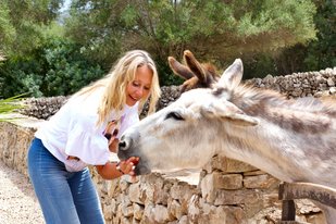 Eine Frau streichelt einen Esel